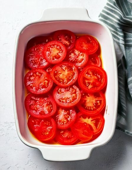 Frische Tomatenscheiben in die Auflaufform geben. 2 Zutaten später: Ein ... Frische Tomatenscheiben in die Auflaufform geben. 2 Zutaten später: Ein ...